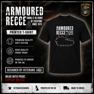 A black short-sleeve T-shirt displayed on a dark promotional graphic with text reading 'ARMOURED RECCE' and a tank illustration on the chest. The image includes marketing callouts such as 'Printed T-Shirt,' 'Premium Quality Soft Cotton,' 'High Quality Front Print,' and 'Printed to Order in the UK,' plus a 'Fat Chimp' logo and 'Veteran Designed' badge.