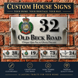 Custom house sign plaque set displayed on a brick wall background, featuring a large silver metal sign for '32 Old Beck Road' with a crest emblem, plus four smaller sample signs below showing different addresses and text options. The top banner reads 'Custom House Signs' and the bottom section includes feature callouts.