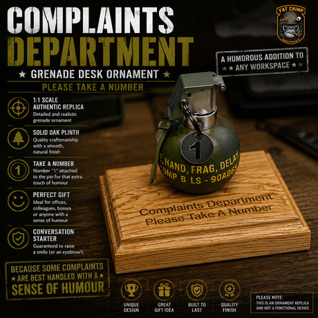 A humorous desk ornament shaped like a military grenade with printed text reading 'COMPLAINTS DEPARTMENT' and 'Please Take A Number,' displayed on a wooden box with product feature callouts around it.