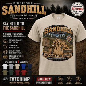A beige graphic t-shirt displayed on a dark promotional background. The shirt features a large vintage-style military-themed graphic with the text 'Pirbright Sandhill' and 'Say Hello to the Sandhill' with a photo of soldiers on a trail.