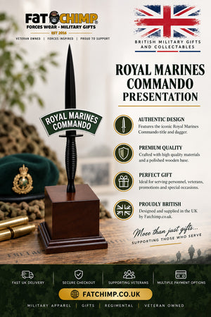 A promotional product image for a 'Royal Marines Commando Presentation' dagger from the brand Fat Chimp. The dagger features a polished steel blade with a green enamel and black ribbon 'Royal Marines Commando' insignia, mounted on a dark wooden presentation block.