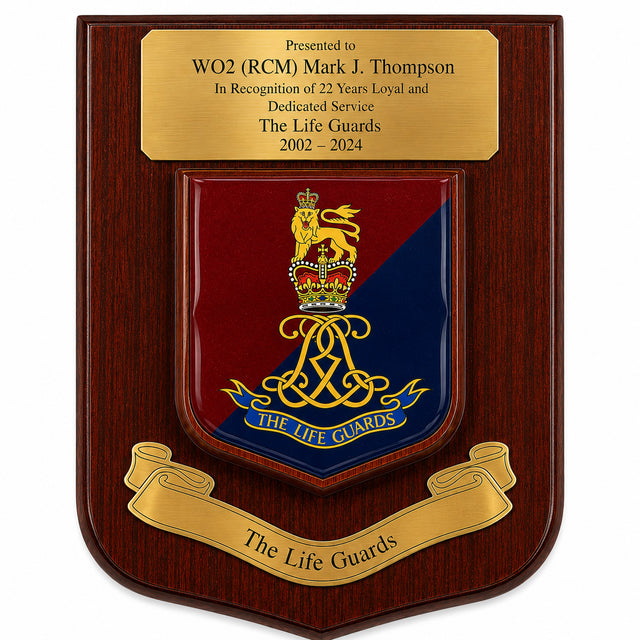 A wooden commemorative plaque with a polished gold-tone top inscription plate and a central shield featuring the Life Guards crest in red and blue with gold detailing, plus a gold scroll reading 'The Life Guards' at the bottom.
