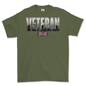 An olive green short-sleeve t-shirt with a graphic on the chest reading 'VETERAN' in distressed white letters, featuring soldier silhouettes and a Union Jack flag underneath, shown on a plain white background.