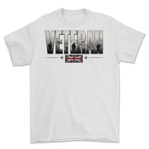 A white short-sleeve crewneck t-shirt featuring a graphic print on the front. The graphic displays the word 'VETERAN' in distressed gray block letters filled with military silhouettes, a small Union Jack flag, and two stars.