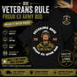 A black graphic T-shirt shown on a dark promotional background with text overlays. The shirt features a large front print reading 'VETERANS RULE PROUD EX ARMY BOO' around a portrait of a military man, with small Union Jack flags.