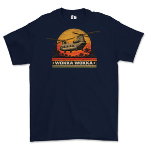 A navy blue short-sleeve t-shirt with a retro-style graphic of a military helicopter flying over a sunset with palm trees and the text 'WOKKA WOKKA'.